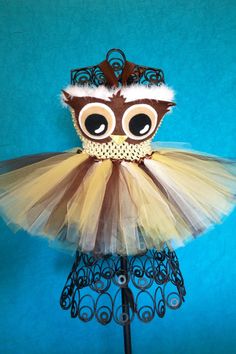 a brown and white owl costume on top of a mannequin headdress