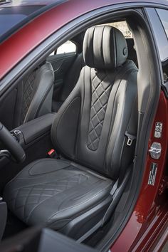 the interior of a red car with black leather and stitching on it's seats