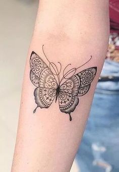 a woman's arm with a butterfly tattoo on the left side of her arm