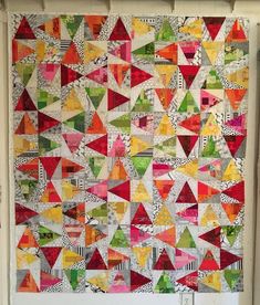 a large colorful quilt hanging on the wall