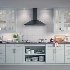 a kitchen filled with lots of counter top space next to a wall mounted oven and range hood