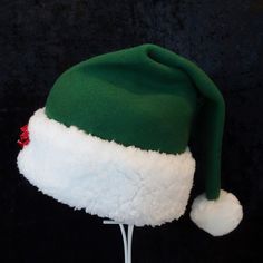 "Novelty green fleece Santa hat is decked out with a few red jingle bells to add a festive touch to this classic hat. The fabric is a warm cozy green poly fleece and the trim is a white soft faux Sherpa fur. There is a snowy white pompom stitched on the top of the hat and the fur trim is accented with 3 red jingle bells. Hat is a slouch cone styling with generous sizing between 25-26\" opening for your head and a length of 18\". If you need more hats than this listing, send me a message. Custom Green Winter Costume Hats And Headpieces, Green Mini Cap For Winter, Green Winter Mini Cap, Winter Green Mini Cap, Novelty Hats, Bells Christmas, Santa Claus Hat, Elf Hat, Classic Hats