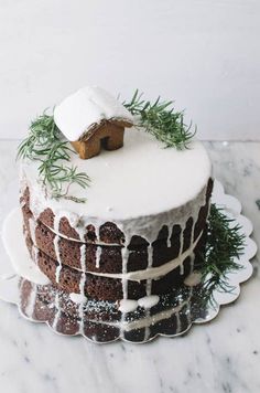 a frosted cake with icing and greenery on top