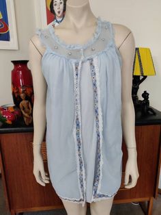 This is a shortie nightie from the 60s in a pretty pale blue nylon in a vintage size 18 to fit a 40inch bust. The nightie has a sheer yolk with a frill and appliques, bow this are two layers the under is an opaque fabric and the top is a sheer split at the front and edged with lace and a flower embroidery which continues along the hemline. The condition is good vintage with no faults to note. The measurements are Bust Length shoulder to hem Women's Nightgowns, Nightgowns, Flower Embroidery, Embroidery Flowers, Baby Doll, Pale Blue, Night Dress, No Frills, Night Gown