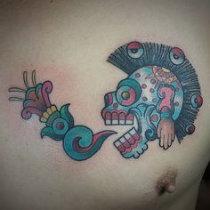 a man with a colorful skull tattoo on his chest