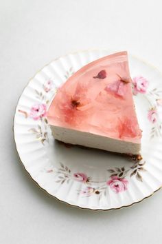 a piece of cake sitting on top of a white and gold plate with pink flowers