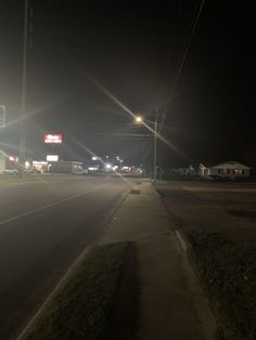 an empty street at night with no cars on the road or people in the distance