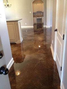 an open door leading to a kitchen and living room in a house with marble floors