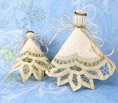 two small white doily christmas trees on a blue background