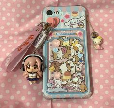 a cell phone with a key chain attached to it next to a small animal figure