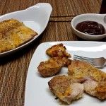 two white plates with food on them sitting on a table next to some sauces