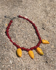 Handmade polymer clay pendants with red beads and an adjustable clasp Handmade Resin Necklaces With Round Beads, Resin Beaded Necklaces For Gifts, Beaded Resin Necklaces For Gifts, Resin Beaded Necklace Gift, Gift Beaded Resin Necklaces, Red Polished Bead Necklaces For Beach, Handmade Adjustable Red Coral Necklace, Colorful Round Beaded Resin Jewelry, Handmade Orange Resin Necklace