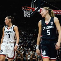 two female basketball players standing on the court