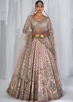 Pale peach raw silk bridal lehenga with gold and silver kamdani work and an embroidered choli. Teamed with a kamdani dupatta and a head veil with a trail. Peach Anarkali Set For Reception With Traditional Drape, Peach Lehenga With Traditional Drape For Reception, Traditional Drape Peach Lehenga For Reception, Peach Floor-length Lehenga For Reception, Floor-length Peach Lehenga For Reception, Floor-length Peach Choli For Reception, Floor-length Anarkali Choli In Peach, Peach Anarkali Set For Reception, Designer Peach Lehenga With Intricate Embroidery