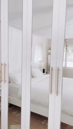 an image of a bedroom through the glass door framers in this room with white furniture