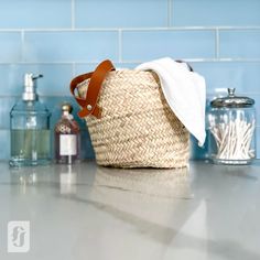 a basket sitting on top of a counter next to bottles and soap dispensers