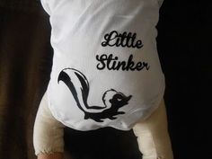 a stuffed animal that is wearing a little stinker t - shirt on it's back