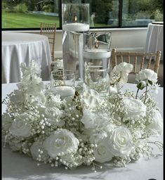 white flowers and candles are on the table