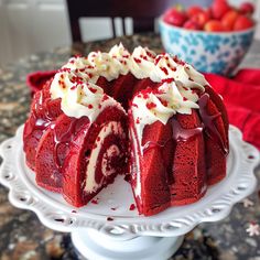 a red velvet cake with white frosting and strawberries in the background on a plate