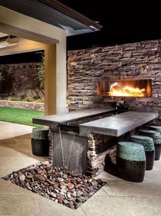 an outdoor fireplace with several stools around it