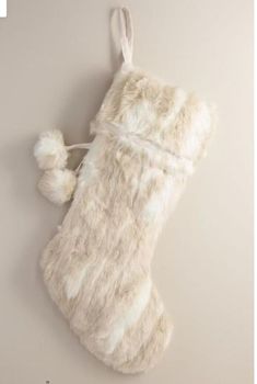 a white stocking hanging on the wall with a pom - pom attached to it