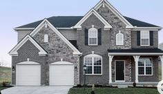 a large brick house with two garages and three windows