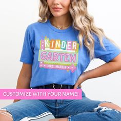 Whether you're looking for a fun and unique gift for a teacher friend or want to treat yourself to something special for the first day of school, this Kindergarten Teacher shirt is sure to bring a smile to your face and to your students'. Find more back to school shirts, sweatshirts and gifts for your favorite Kinder Teacher here: https://www.etsy.com/shop/JaxGraphicTees?search_query=kindergarten All of our adult t-shirts are Bella + Canvas 3001 Unisex shirts. They are a super soft fabric that w Cute Blue T-shirt For End Of School Year, Fun Name Print Tops For School Events, Fun Tops With Name Print For School Events, Blue Graphic Print Top For School Events, Cute Blue Shirt For Gift, Cute Blue Shirt As Gift, Cute Blue Shirt As A Gift, Blue Short Sleeve Top For School Events, Cute T-shirt With Name Print For Teacher Appreciation