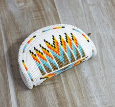 a white beaded purse sitting on top of a wooden floor