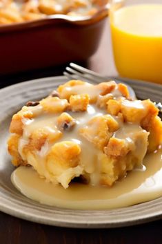 a close up of a plate of food on a table with orange juice in the background