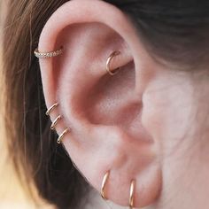 a close up of a person's ear with three piercings on the side