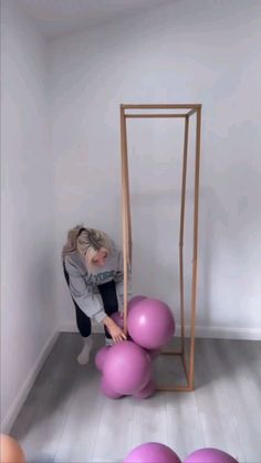 a woman is playing with balloons in an empty room