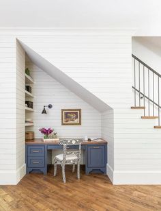 a room with white walls and wooden floors has a desk, chair, and bookshelf in it