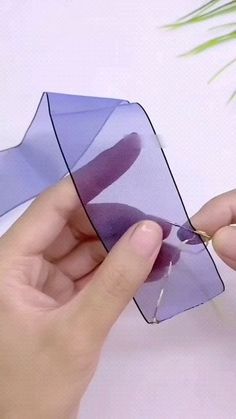 a person is holding a piece of purple material with one hand and the other another