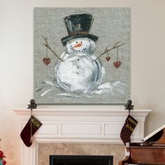 a painting of a snowman is hanging on the fireplace mantel