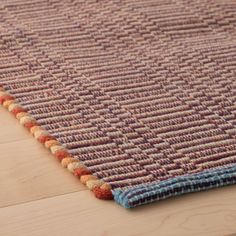 a close up of a rug on a wooden floor with a wood flooring surface