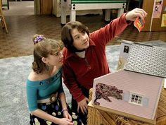 two girls are playing with a doll house