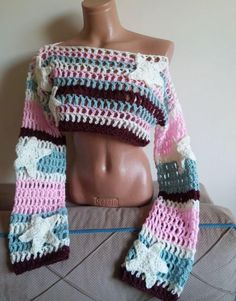 a mannequin wearing a multicolored crocheted sweater and matching scarf