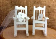 two miniature white chairs with flowers on them