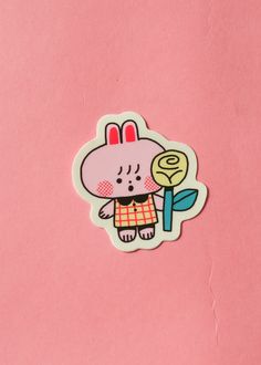 a pink sticker with an image of a rabbit holding a flower in its hand