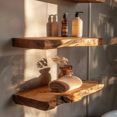 two wooden shelves with towels and soaps on them