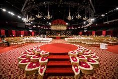 an empty banquet hall with red carpet and chandeliers