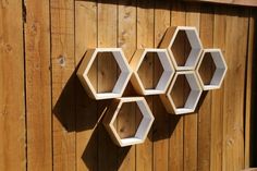 three hexagonal shelves mounted to a wooden fence