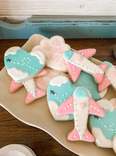 decorated cookies in the shape of airplanes on a plate