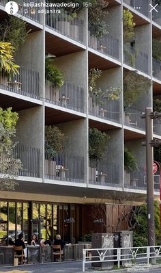 an apartment building with plants growing on the balconies