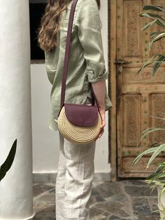 A limited edition style crafted from raffia and full-grain leather that celebrates connection and craftsmanship. This bag was a collaboration between two women-run cooperatives in Marrakech Natural Color Crossbody Shoulder Bag With Removable Pouch, Natural Crossbody Shoulder Bag With Removable Pouch, Ethically Sourced Natural Shoulder Bag For Everyday Use, Leather Crossbody Beach Bag, Leather Crossbody Bucket Bag For Vacation, Ethically Sourced Tote Bags, Ethically Sourced Bags For Vacation, Handwoven Leather Crossbody Shoulder Bag, Leather Straw Crossbody Bag For Vacation