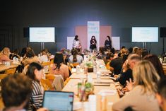 a group of people sitting at tables with laptops in front of them on stage