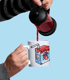 a person pouring red liquid into a coffee mug with a carton of milk on it