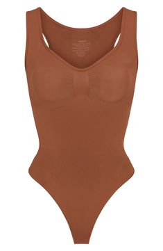 From Kim Kardashian's SKIMS, this curve-hugging bodysuit with a thong back gives support and disappears under clothes. Snap closure Scoop neck Sleeveless 41% recycled nylon, 41% nylon, 18% elastane Machine wash, tumble dry Imported High Cut High Stretch Bodysuit With Built-in Bra, Stretch Nylon Bodysuit With Built-in Bra, Stretch Leotard With Built-in Bra And Scoop Neck, Sleeveless Nylon Seamless Leotard, Solid Seamless Scoop Neck Shapewear, Seamless Solid Shapewear With Scoop Neck, Solid Color Seamless Shapewear With Scoop Neck, Sculpting Sleeveless Bodysuit With Medium Bust Support, Sleeveless Stretch Nylon Shapewear