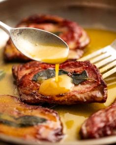 a fork is being drizzled with sauce on top of some meat patties