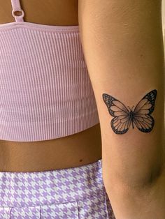 a woman's arm with a butterfly tattoo on the left side of her body